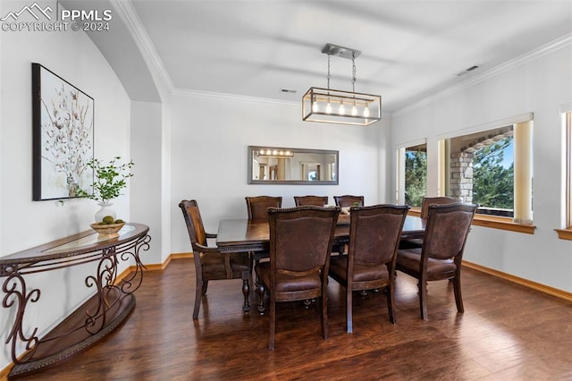 dining room featuring dark hardwood / wood-style floors, an inviting chandelier, and ornamental molding