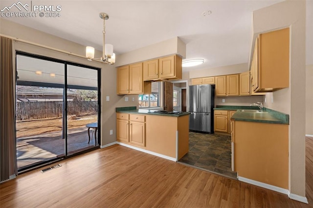 kitchen with sink, dark wood-type flooring, light brown cabinetry, and stainless steel refrigerator