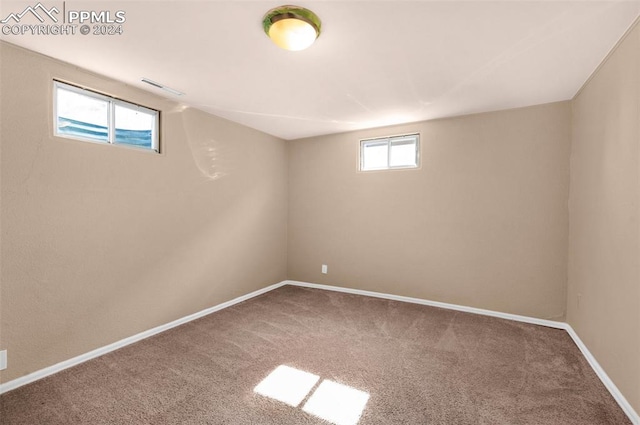 basement with a healthy amount of sunlight and carpet