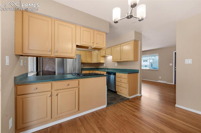 kitchen featuring dark hardwood / wood-style flooring, light brown cabinets, stainless steel appliances, pendant lighting, and a chandelier