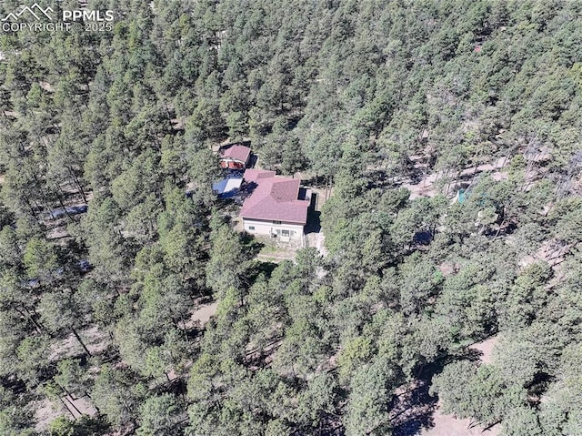 bird's eye view with a wooded view