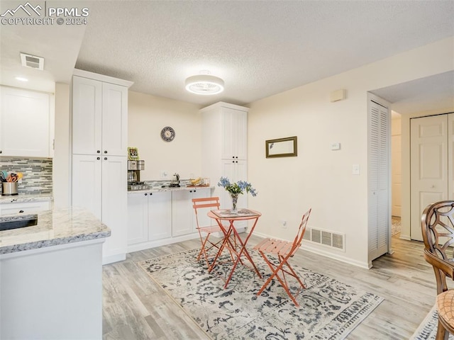 dining room featuring light hardwood / wood-style floors and a textured ceiling