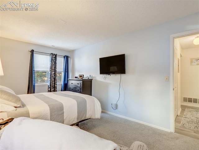 carpeted bedroom with a textured ceiling