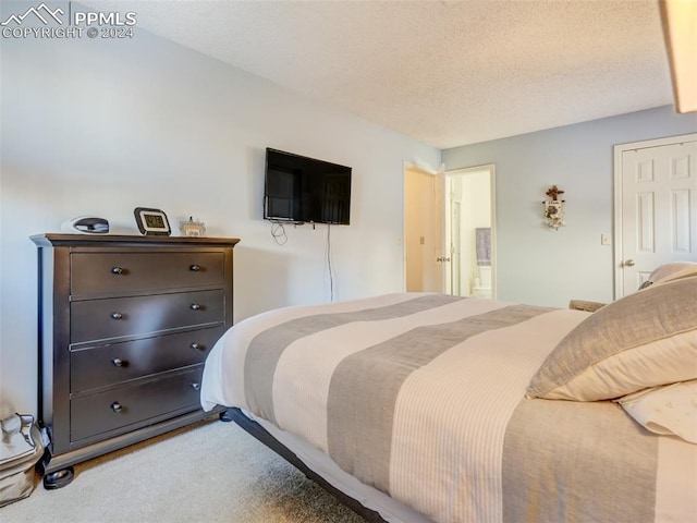 bedroom with carpet floors and a textured ceiling