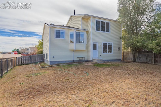 rear view of house with a yard