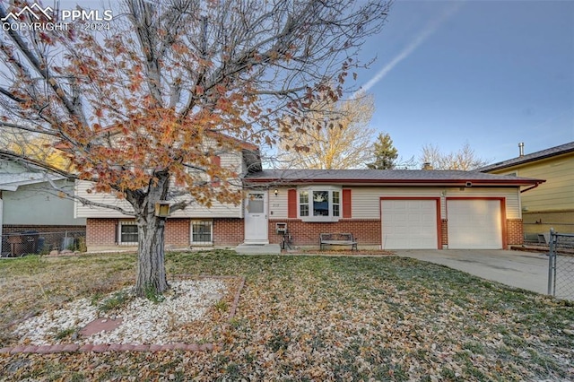 split level home featuring a garage and a front lawn