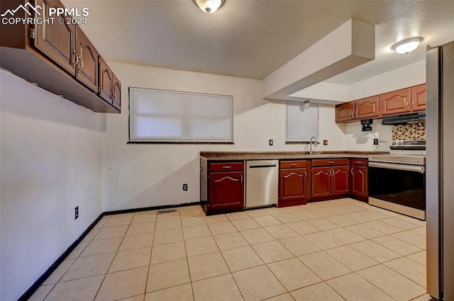 kitchen with appliances with stainless steel finishes, sink, and light tile patterned floors