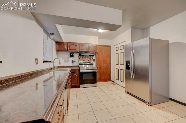 kitchen featuring tasteful backsplash, sink, light tile patterned floors, and stainless steel appliances