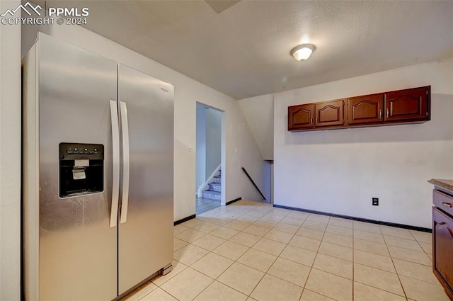 kitchen featuring stainless steel fridge, a textured ceiling, and light tile patterned floors