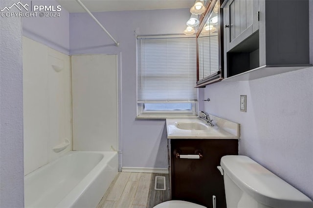 full bathroom with shower / washtub combination, wood-type flooring, toilet, and vanity