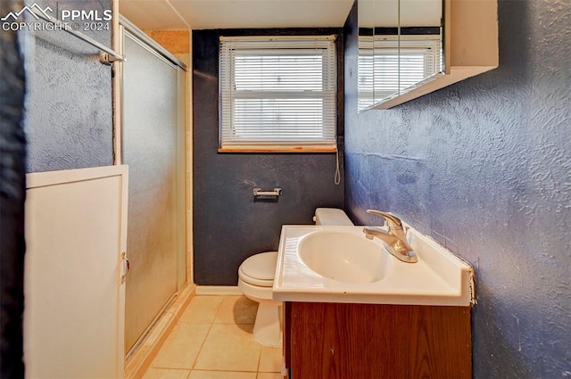 bathroom with vanity, a shower with shower door, tile patterned flooring, and toilet