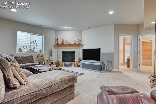 living room featuring a tiled fireplace and light colored carpet