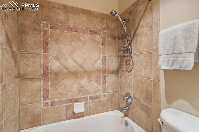 bathroom with tiled shower / bath and toilet