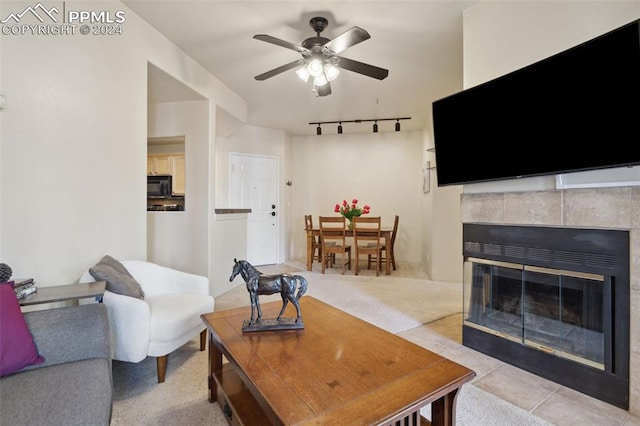 175 W Cheyenne Rd Unit 214, Colorado Springs, CO 80906 - living area with a ceiling fan, a tiled fireplace, rail lighting, and light carpet