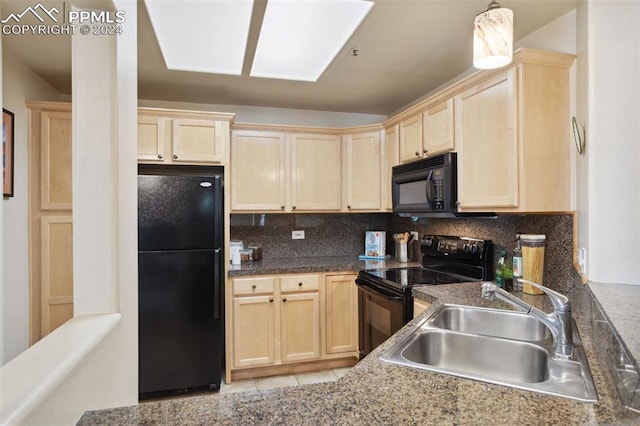 kitchen with tasteful backsplash, black appliances, sink, and a skylight