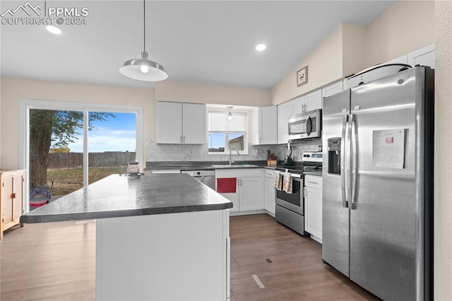 kitchen with white cabinetry, sink, appliances with stainless steel finishes, a center island, and pendant lighting