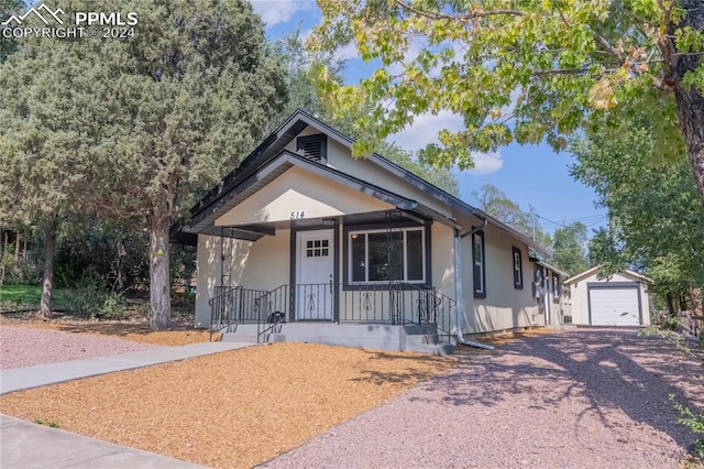 bungalow-style home featuring a garage, an outdoor structure, and covered porch