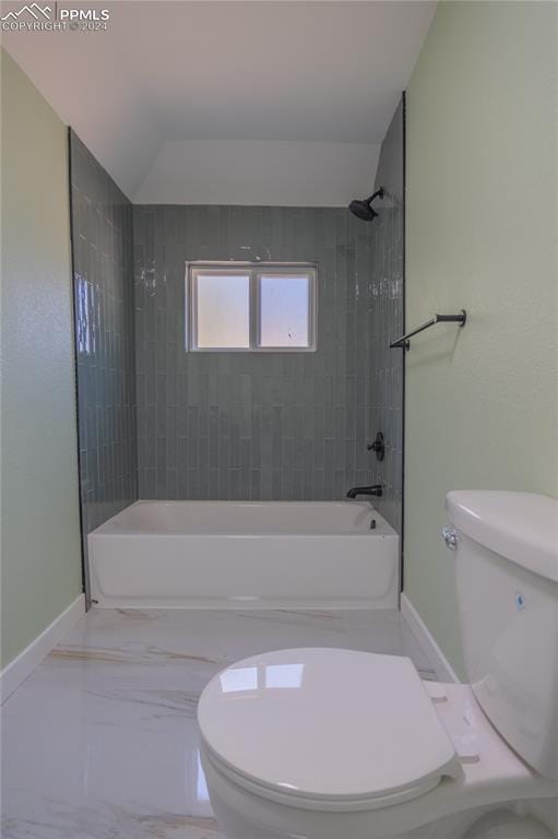 bathroom with toilet, tiled shower / bath, and vaulted ceiling