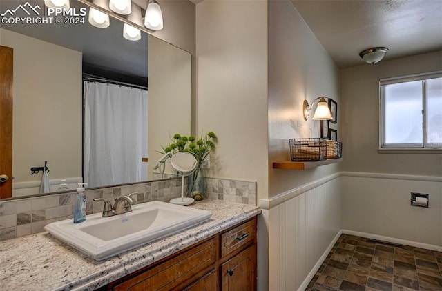 bathroom featuring vanity and tasteful backsplash