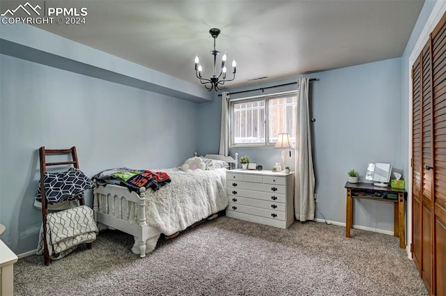 bedroom featuring a closet, a chandelier, and carpet flooring