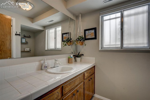 bathroom featuring a wealth of natural light and vanity