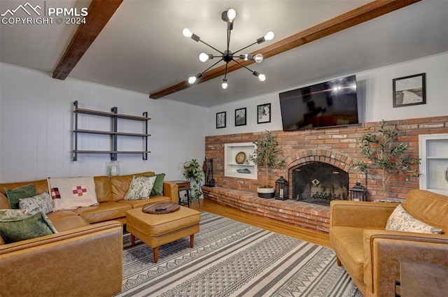 living room with beamed ceiling, hardwood / wood-style floors, a notable chandelier, and a brick fireplace