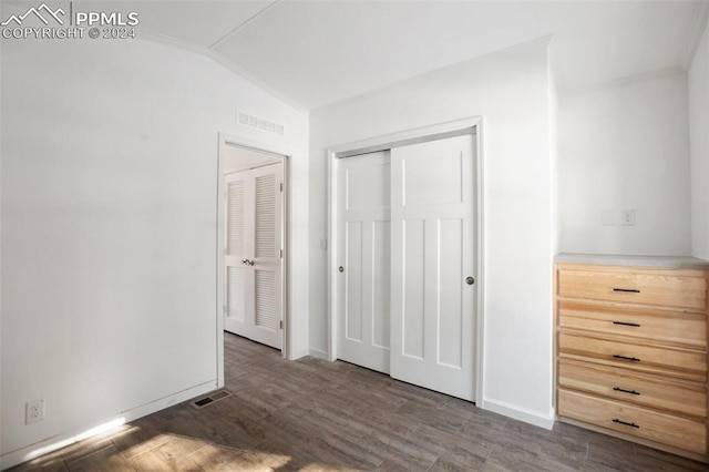 unfurnished bedroom with dark hardwood / wood-style floors, crown molding, and vaulted ceiling