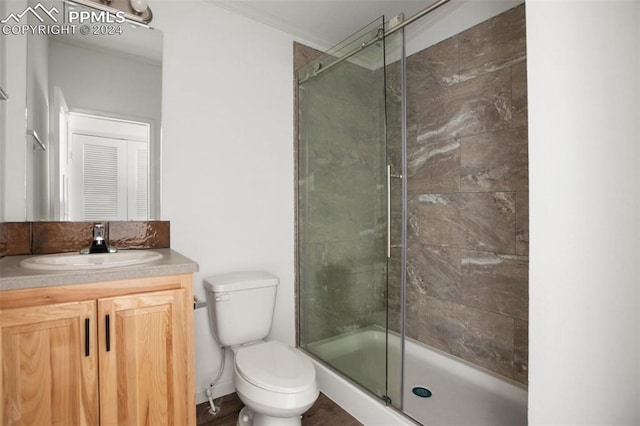 bathroom featuring vanity, toilet, walk in shower, and ornamental molding