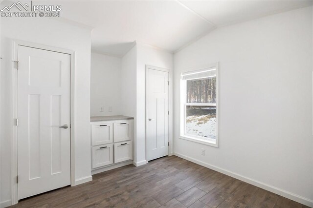 unfurnished bedroom featuring wood-type flooring and lofted ceiling