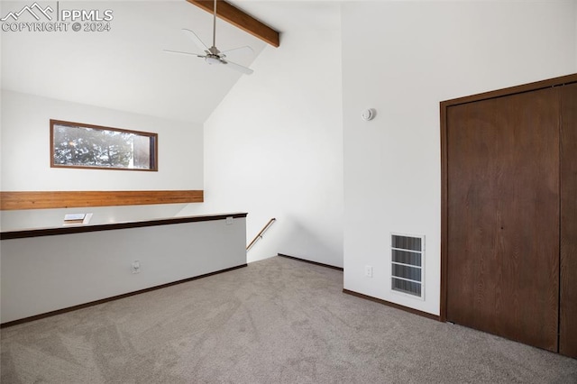 empty room with beam ceiling, ceiling fan, high vaulted ceiling, heating unit, and light colored carpet