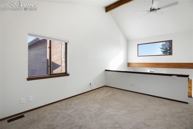 empty room with beamed ceiling, light colored carpet, ceiling fan, and a healthy amount of sunlight