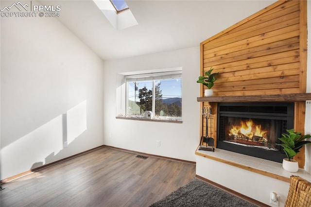 unfurnished living room with lofted ceiling with skylight and hardwood / wood-style floors