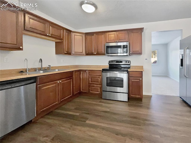 kitchen with stainless steel appliances, sink, and dark hardwood / wood-style floors