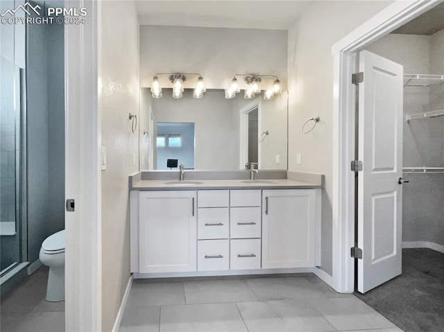 bathroom with tile patterned floors, vanity, toilet, and an enclosed shower