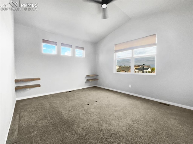 carpeted empty room featuring ceiling fan, a healthy amount of sunlight, and vaulted ceiling