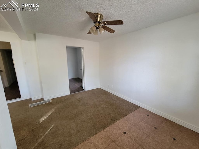 unfurnished room featuring a textured ceiling, ceiling fan, and dark carpet