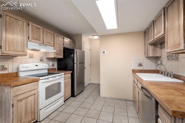 kitchen featuring stainless steel appliances, tasteful backsplash, sink, and light brown cabinetry