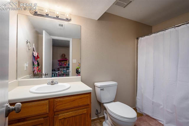 bathroom with curtained shower, vanity, and toilet