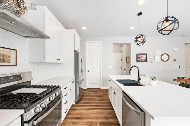 kitchen with stainless steel appliances, dark hardwood / wood-style floors, pendant lighting, sink, and wall chimney exhaust hood