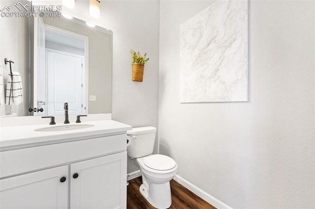 bathroom featuring wood-type flooring, vanity, and toilet