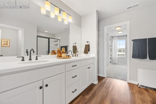 bathroom with vanity, wood-type flooring, and a shower with shower door