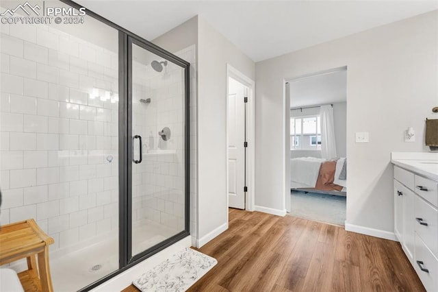 bathroom featuring vanity, hardwood / wood-style floors, and a shower with shower door