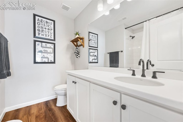 bathroom with walk in shower, vanity, hardwood / wood-style flooring, and toilet