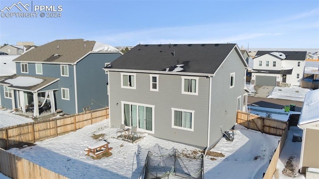 view of snow covered rear of property