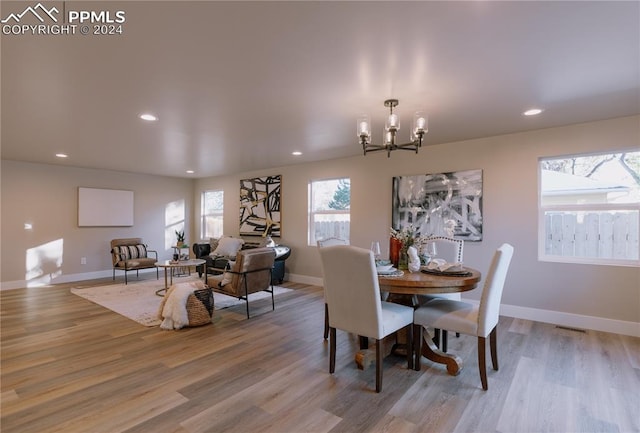 dining area featuring light wood-type flooring and an inviting chandelier