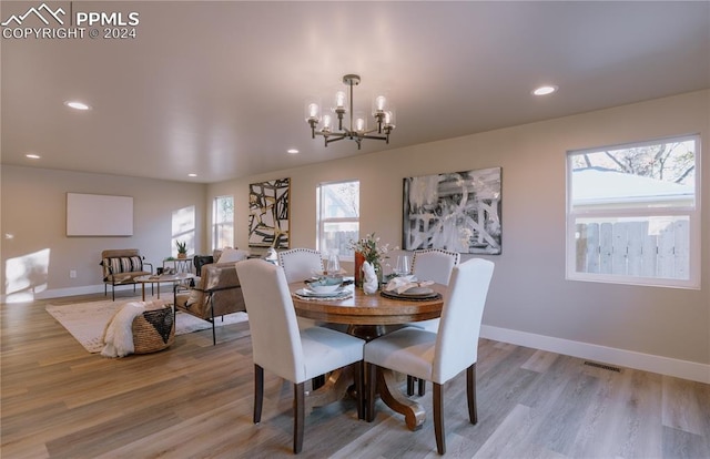 dining area featuring light hardwood / wood-style flooring and an inviting chandelier