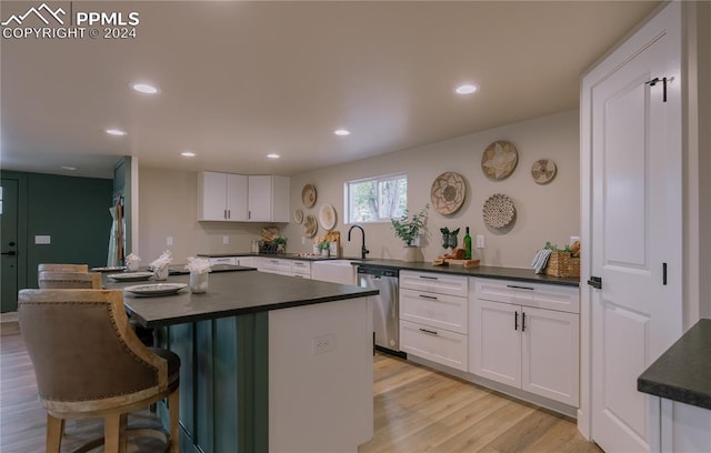 kitchen featuring a center island, dishwasher, light hardwood / wood-style floors, and white cabinetry