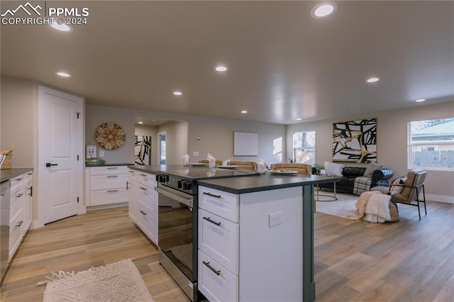 kitchen featuring light wood-type flooring, stainless steel appliances, and white cabinetry