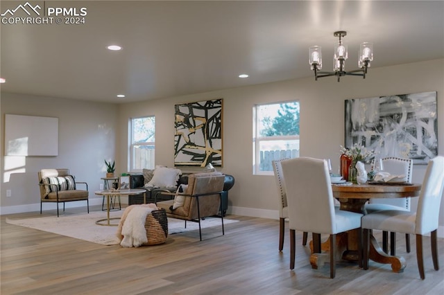 dining space featuring a wealth of natural light, an inviting chandelier, and light wood-type flooring