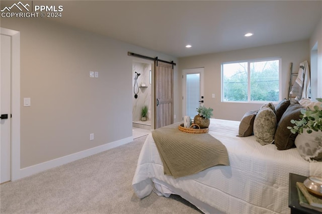 bedroom featuring a barn door and light carpet